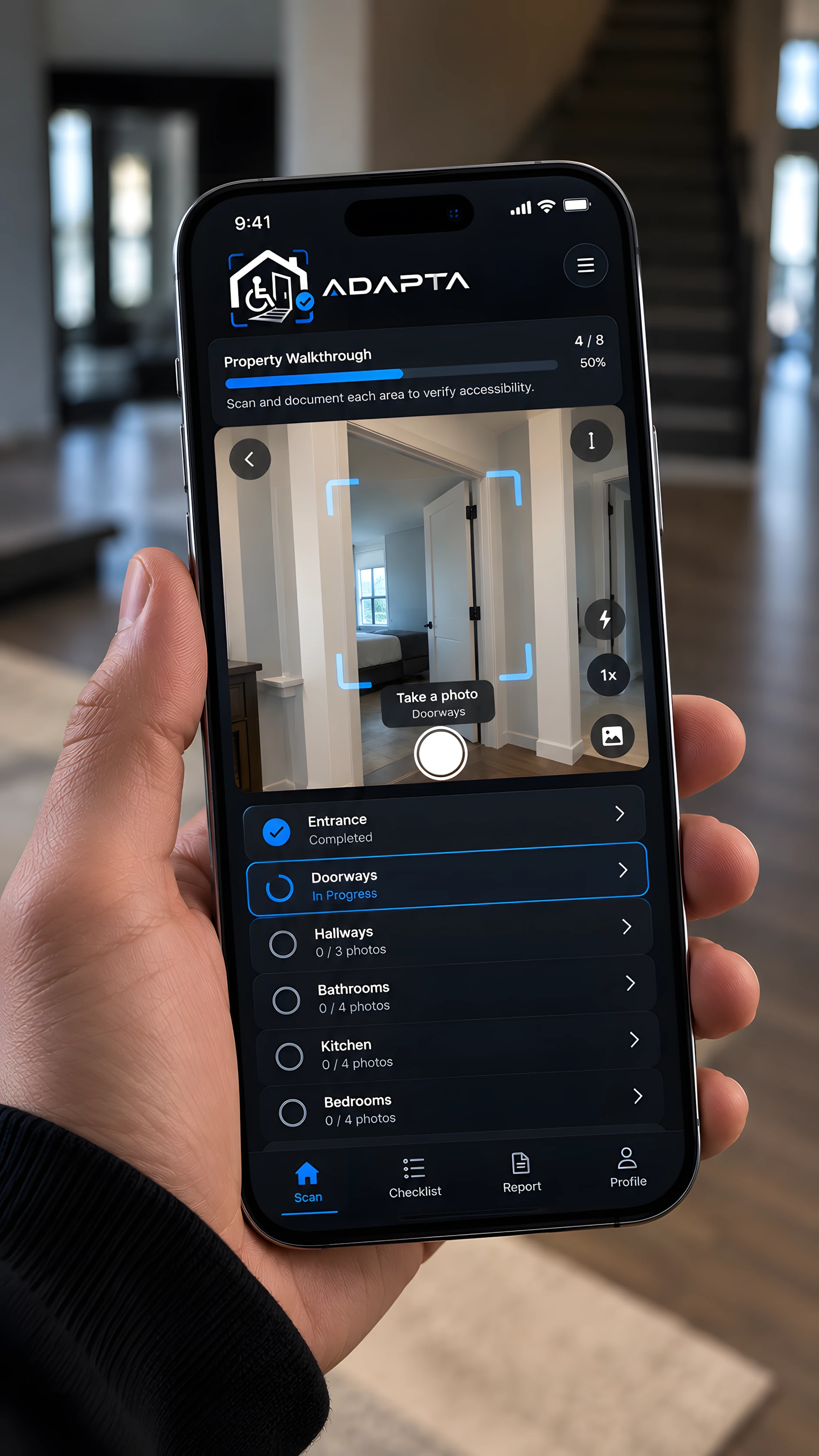 Hand holding a phone showing an Adapta property walkthrough, with the doorway step in progress